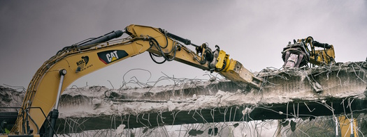 Excavators dismantle an old concrete structure.